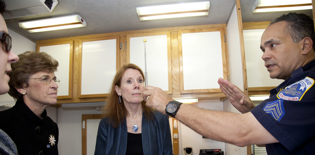 A police officer demonstrates a horizontal gaze nystagmus test to two trainees.